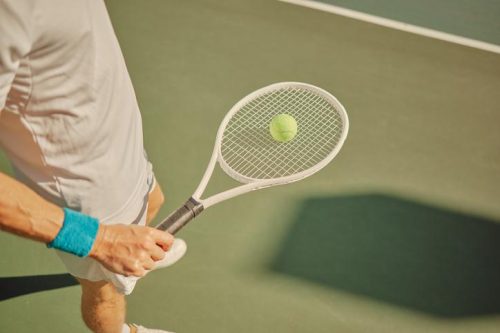Sports, fitness and tennis racket with hand of man on court for training practice, serve and workout. Health, wellness and focus with athlete and playing for exercise, competition and game match